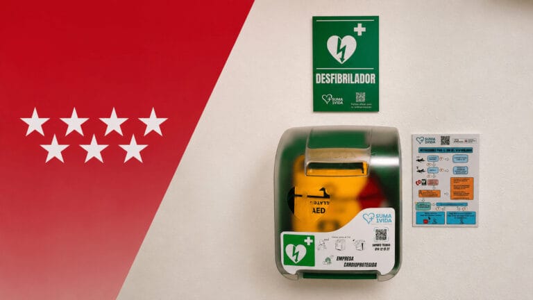 Desfibrilador DEA instalado en pared junto a señalización e instrucciones de uso, con diseño inspirado en la Comunidad de Madrid para artículo sobre normativa de desfibriladores.